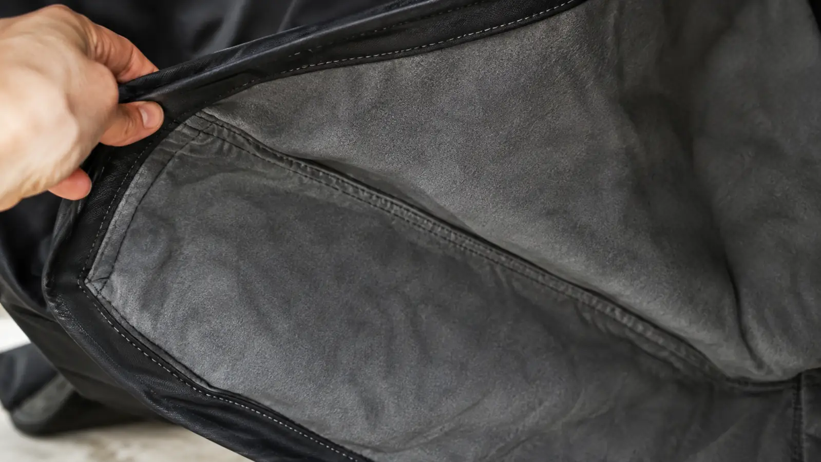 A close view of the underside of a motorcycle cover showing the soft lining and the stitched seams